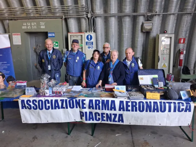 Soci e visitatori davanti al banco dell'associazione sotto l'hangar dell'aeroporto