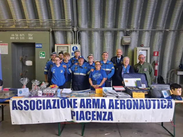 Un gruppo in divisa blu in visita allo stand della sezione di Piacenza