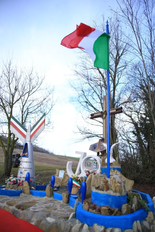 Il monumento ai piloti con le ali tricolori, la Croce dei Venti e la bandiera
