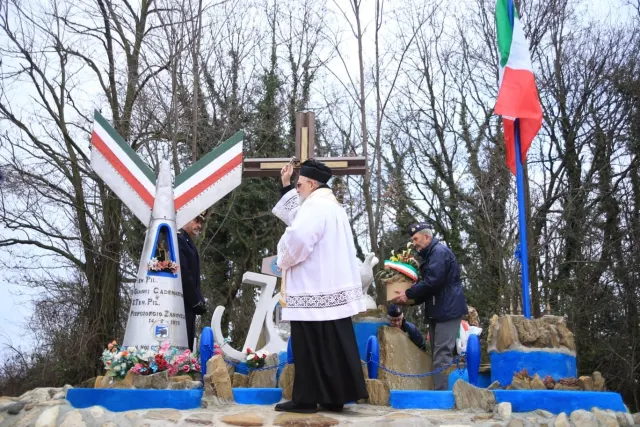 Il sacerdote benedice il monumento